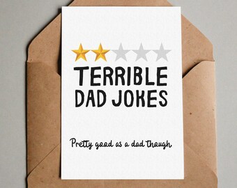 Könnte beinhalten: Eine weiße Karte mit einem braunen Umschlag. Die Karte hat eine Bewertung von zwei von fünf Sternen mit dem Text "Terrible Dad Jokes" und "Pretty good as a dad though".