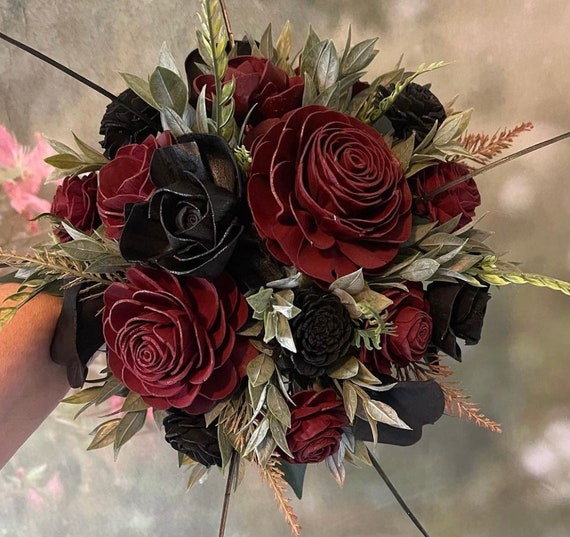 My work, deep red roses, and feathers in a black vase trimmed with