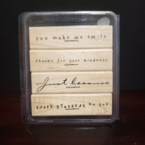 May include: Set of four wooden stamps with the following phrases: "you make me smile", "thanks for your kindness", "just because", and "happy birthday to you".