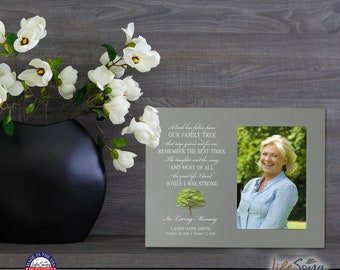 May include: A gray picture frame with a photo of a woman smiling. The frame has a quote about a family tree and a tree illustration. The text reads: "A limb has fallen from our family tree that says grieve not for me. Remember the best times, the laughter and the song. And most of all, the good life I lived while I was strong. In Loving Memory, Laurie Anne Smith, October 22, 1952 - January 2, 2018."