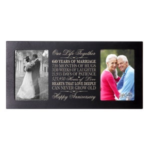 May include: Black wooden picture frame with two photo openings and a gold inscription that reads "Our Life Together 60 Years of Marriage 720 Months of Hugs 3130 Weeks of Laughter 21,915 Days of Patience 525,950 Hours of Love Hearts That Love Deeply Can Never Grow Old Happy Anniversary".