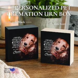 May include: Two square pet cremation urn boxes, one black and one ivory, each featuring a photo of a golden retriever and the text: A HEART of Gold stopped beating, FOUR LITTLE PAWS AT REST, It broke my heart but THIS I KNOW God only takes the best, Charlie 2015-2021.