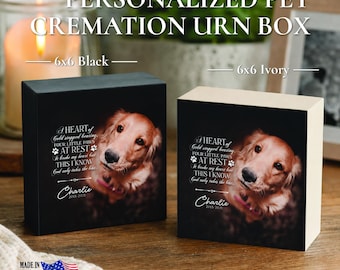May include: Two square pet cremation urn boxes, one black and one ivory, each featuring a photo of a golden retriever and the text: A HEART of Gold stopped beating, FOUR LITTLE PAWS AT REST, It broke my heart but THIS I KNOW God only takes the best, Charlie 2015-2021.