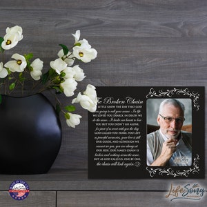 May include: Black framed photo memorial with a white background and a white inscription that reads "The Broken Chain". The inscription is a poem about loss and grief. The photo shows a man with glasses and a white shirt. The frame has a decorative border.