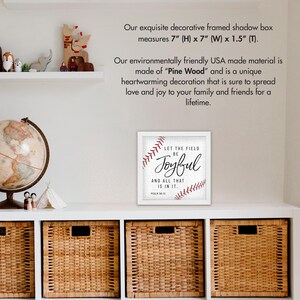 May include: White framed shadow box with a baseball-themed print that reads "Let the field be Joyful and all that is in it. Psalm 36:12". The print is on a white background with red stitching around the baseball.