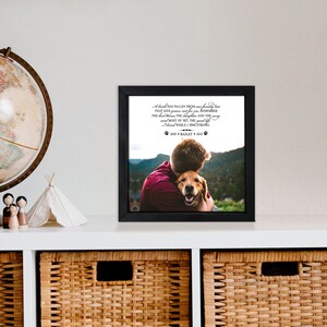 May include: A black framed photo with a picture of a man hugging a dog. The photo has a text overlay that reads "A friend has fallen from our family tree that says grieve not for me, remember the best times, the laughter and the song and most of all, the good life I lived while I was strong. 2010 * Bailey * 2021"