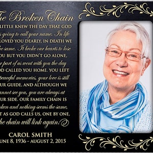May include: Black wooden picture frame with a gold inscription that reads "The Broken Chain" and a poem about loss and grief. The frame has a gold border and a photo of a smiling woman with gray hair wearing glasses and a blue scarf. The inscription at the bottom reads "CAROL SMITH JUNE 8, 1936 - AUGUST 2, 2015".