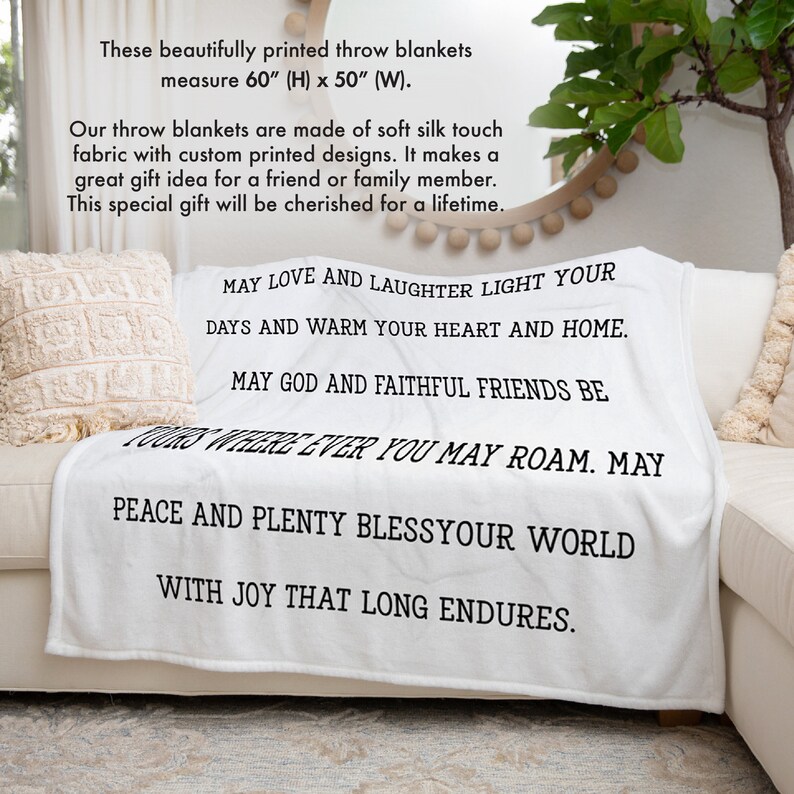 May include: White throw blanket with black text that reads "May love and laughter light your days and warm your heart and home. May God and faithful friends be yours wherever you may roam. May peace and plenty bless your world with joy that long endures."