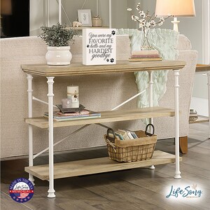 May include: A white wooden shelf with two shelves and white metal legs. The shelf is decorated with a small wooden sign that reads "You were my FAVORITE hello and my HARDEST goodbye" with paw prints. The shelf is sitting on a wooden floor.