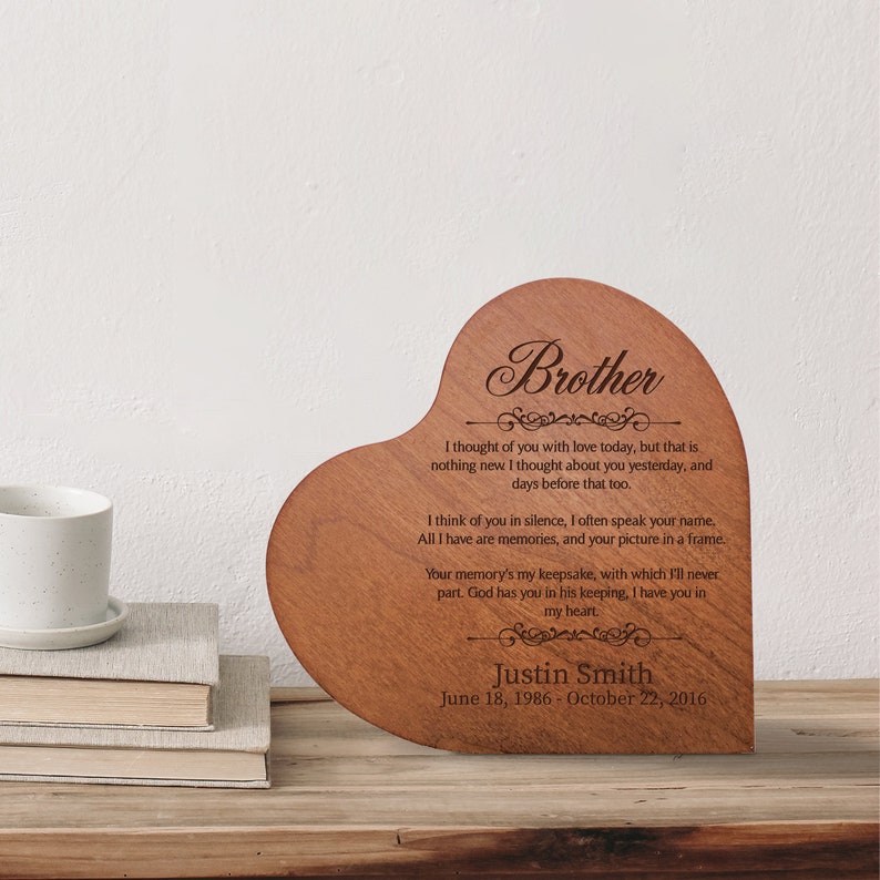May include: A wooden heart-shaped plaque with a laser-engraved message about a brother. The message reads "I thought of you with love today, but that is nothing new I thought about you yesterday, and days before that too. I think of you in silence, I often speak your name. All I have are memories, and your picture in a frame. Your memory's my keepsake, with which I'll never part. God has you in his keeping, I have you in my heart." The plaque also includes the name "Justin Smith" and the dates "June 18, 1986 - October 22, 2016".
