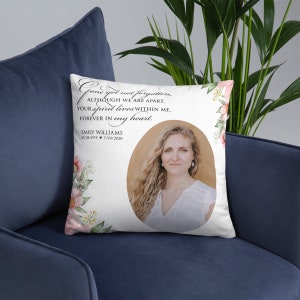 May include: White square pillow with a photo of a woman and floral accents. Text reads "Gone yet not forgotten, although we are apart, your spirit lives within me, forever in my heart." Includes name and dates.