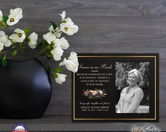 May include: Black and gold picture frame with a photo of a woman smiling. The frame has a floral design and the text "Forever in our Hearts" and "Because someone we love is in heaven, there's a little bit of heaven in our home." The text also includes "loving wife, daughter and friend Grace Susan Smith April 23, 1989 - June 6, 2019".