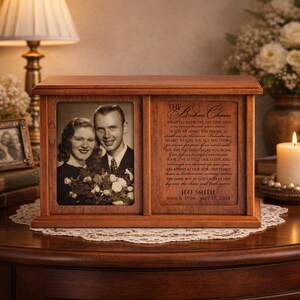 May include: A wooden memorial urn with a framed photo of a couple and a poem titled "The Broken Chain." The urn is brown with a rectangular shape and a hinged lid. The text includes the name Jeff Smith and dates.