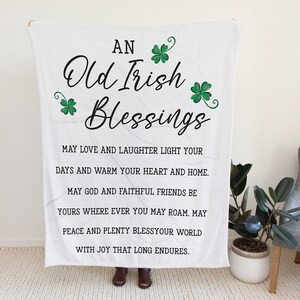 May include: White throw blanket with green shamrocks and black text that reads "An Old Irish Blessings" and a poem about love, laughter, and joy.