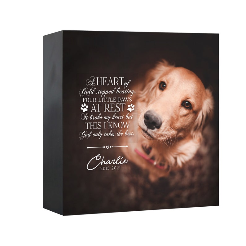 May include: A black rectangular memorial block featuring a golden retriever looking upward. The text reads: A HEART of Gold stopped beating, FOUR LITTLE PAWS AT REST It broke my heart but THIS I KNOW God only takes the best. Charlie 2015-2021.
