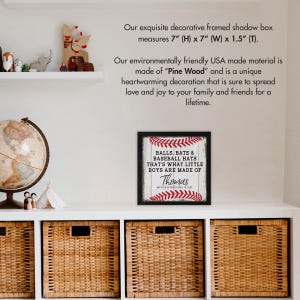 May include: A framed shadow box with a baseball-themed design. The text reads "Balls, Bats & Baseball Hats That's What Little Boys Are Made Of." The name "Thomas" is printed below the text. The frame is black and the background is white with red stitching.