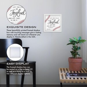 May include: A framed shadow box with a white background and red stitching around the edges. The box features a baseball graphic with the text "Let the field be joyful and all that is in it."  Psalm 126:6.