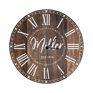May include: A round wooden clock with Roman numeral markings and a white inscription that reads "Miller Est. 1976".