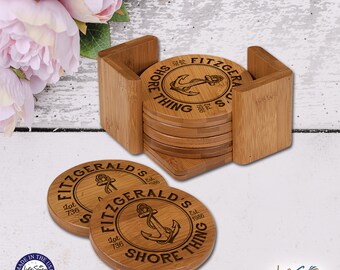 May include: Set of six bamboo coasters with a holder. Each coaster features a nautical design with an anchor and the text "Fitzgerald's Shore Thing" with the establishment date "Est. 1986" and lot number "Lot 736".