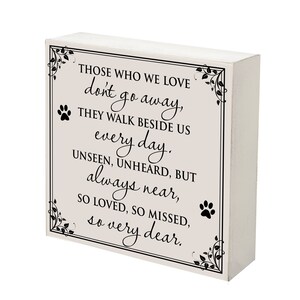 May include: A white wooden block sign with the text "THOSE WHO WE LOVE don't go away, THEY WALK BESIDE US every day. UNSEEN, UNHEARD, BUT always near, SO LOVED, SO MISSED, so very dear." Features paw prints and floral corner accents.