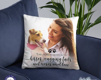 May include: White square throw pillow with a photo of a woman and a dog. The dog is wearing a pink bandana. Text on the pillow reads "THIS HOME IS FILLED WITH kisses, wagging tails, wet noses and love."