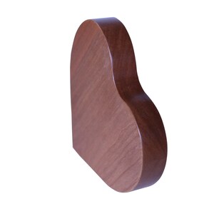 May include: A heart-shaped wooden plaque, made of dark brown wood. The plaque is smooth and has a slightly rounded edge.