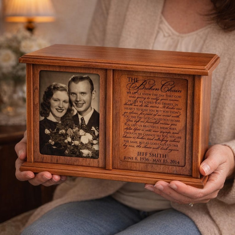 May include: A wooden urn with a framed photograph and engraved text. The photograph shows a smiling couple. The text includes a poem titled "The Broken Chain" and the name and dates "Jeff Smith, June 8, 1936 - May 15, 2014."