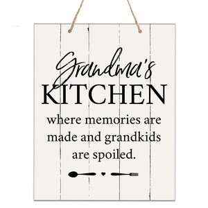 May include: White wooden sign with black text that reads "Grandma's Kitchen where memories are made and grandkids are spoiled."  The sign has a black spoon and fork with a heart between them at the bottom.