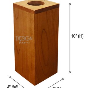 May include: A wooden vase with a clear glass insert, measuring 4 inches wide, 4 inches long, and 10 inches high. The vase is made of cherry wood and has a natural wood finish. The text "DESIGN here" is engraved on the front of the vase.