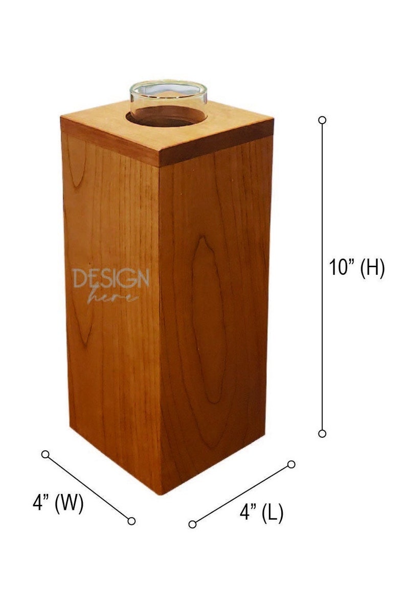 May include: A wooden vase with a clear glass insert, measuring 4 inches wide, 4 inches long, and 10 inches high. The vase is made of cherry wood and has a natural wood finish. The text "DESIGN here" is engraved on the front of the vase.
