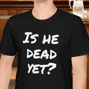 Is He Dead Yet? Funny Mysterious T-Shirt | Bold Party Statement Tee | Radical & Witty Design