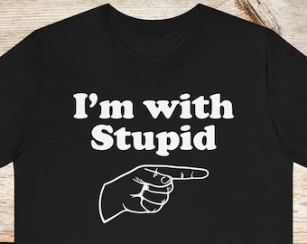 May include: Black t-shirt with white text that reads "I'm with Stupid" and a white pointing hand graphic.