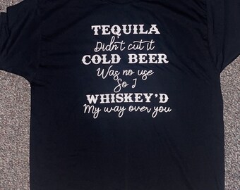 May include: Black t-shirt with white text that reads "TEQUILA Didn't cut it COLD BEER Was no use So I WHISKEY'D My way over you"