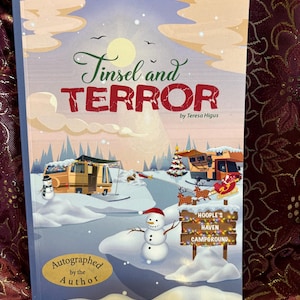 May include: A hardcover book titled "Tinsel and Terror" by Teresa Higus. The cover features a winter scene with RVs, a snowman, and a sign for "Hoople's Haven Campground." The book is autographed by the author.