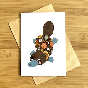 Cartão de felicitações australiano ornitorrinco, vida selvagem nativa, arte original, papel artístico exclusivo, impressão de qualidade, design bonito, floral em branco
