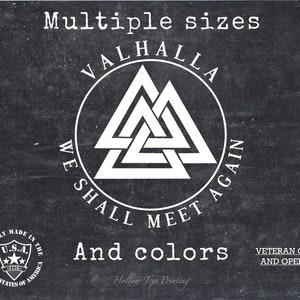 May include: Black and white graphic design with the text "Valhalla We Shall Meet Again" in a circle around a white Valknut symbol. The text "Multiple sizes and colours" is below the circle. The text "Proudly Made in the U.S.A. United States of America" is in a circle in the lower left corner. The text "Veteran Owned and Operated" is in the lower right corner. The text "Hollow Tree Printing" is below the graphic.