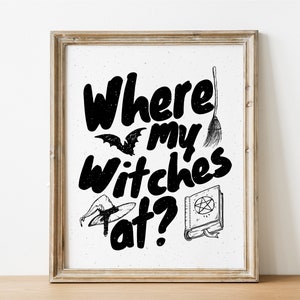 Puede incluir: Una impresión de arte imprimible en blanco y negro con el texto "Where my witches at?" con un sombrero de bruja, una escoba y un libro con un pentagrama en la portada.