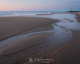 A soft, elegant sunrise over the Ocean City, Maryland seascape beach. Taken at the inlet during low tide.
