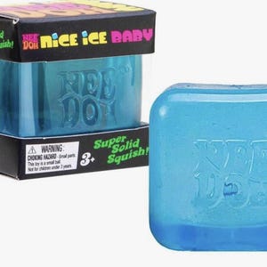 May include: A blue Nee Doh Nice Ice Baby toy, a stress ball, is shown next to its box. The box is black with pink, green, and yellow text. The toy is a translucent blue cube with the Nee Doh logo.