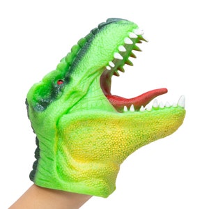 May include: Green and yellow dinosaur puppet with a red tongue and white teeth. The puppet is open-mouthed and has a textured surface.