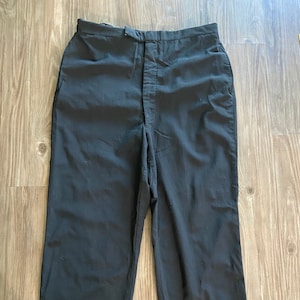 Könnte beinhalten: Schwarze Hose mit Knopfleiste und geradem Bein.