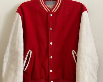 May include: A red and white varsity jacket with a white leather sleeve and red and white striped trim. The jacket has a button closure and a pocket on the left side.