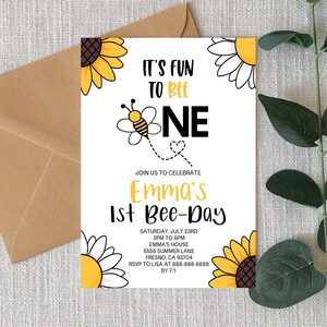 May include: A white invitation card with a yellow and black bee illustration. The text reads "It's Fun to Bee One" and "Emma's 1st Bee-Day". The invitation includes details for the party, including the date, time, location, and RSVP information.