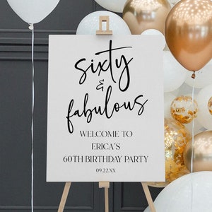 May include: White sign with black calligraphy that reads "sixty & fabulous" with the text "Welcome to Erica's 60th Birthday Party 09.22.XX" below. The sign is on a wooden easel in front of a wall of white and gold balloons.