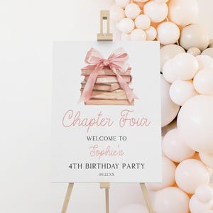 Puede incluir: Un letrero blanco sobre un caballete de madera con el texto "Chapter Four" y "Welcome to Sophie's 4th Birthday Party". El letrero presenta una ilustración de acuarela de libros atados con una cinta rosa. Un arco de globos en el fondo.