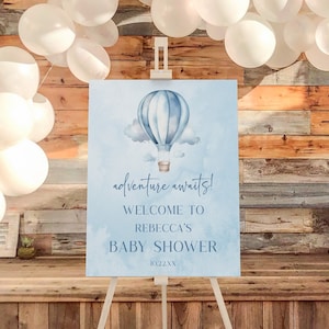 May include: A blue and white hot air balloon with clouds on a light blue background. The sign reads "adventure awaits! Welcome to Rebecca's Baby Shower".