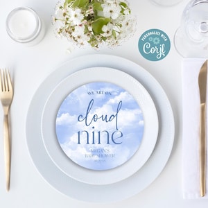 May include: A white plate with a blue and white cloud design with the text "We are on cloud nine" and "Megan's Baby Shower 08.22.2021".