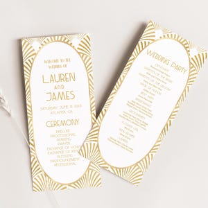 May include: Two wedding ceremony programs with gold art deco design. The programs are white with gold text, including the names Lauren and James, and the date and location of the wedding. One program lists the wedding party.