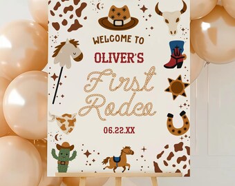 May include: A rectangular welcome sign featuring a western theme with illustrations of a cowboy hat, cow skull, horse, cactus, and horseshoe. The text reads Welcome to Oliver's First Rodeo 06.22.XX in brown and red lettering on a cream background.