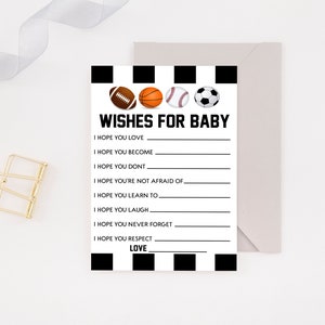 May include: A baby shower game card with the text "Wishes for Baby" and spaces to write wishes. The card features illustrations of a football, basketball, baseball, and soccer ball. The card is black and white with a light gray envelope.